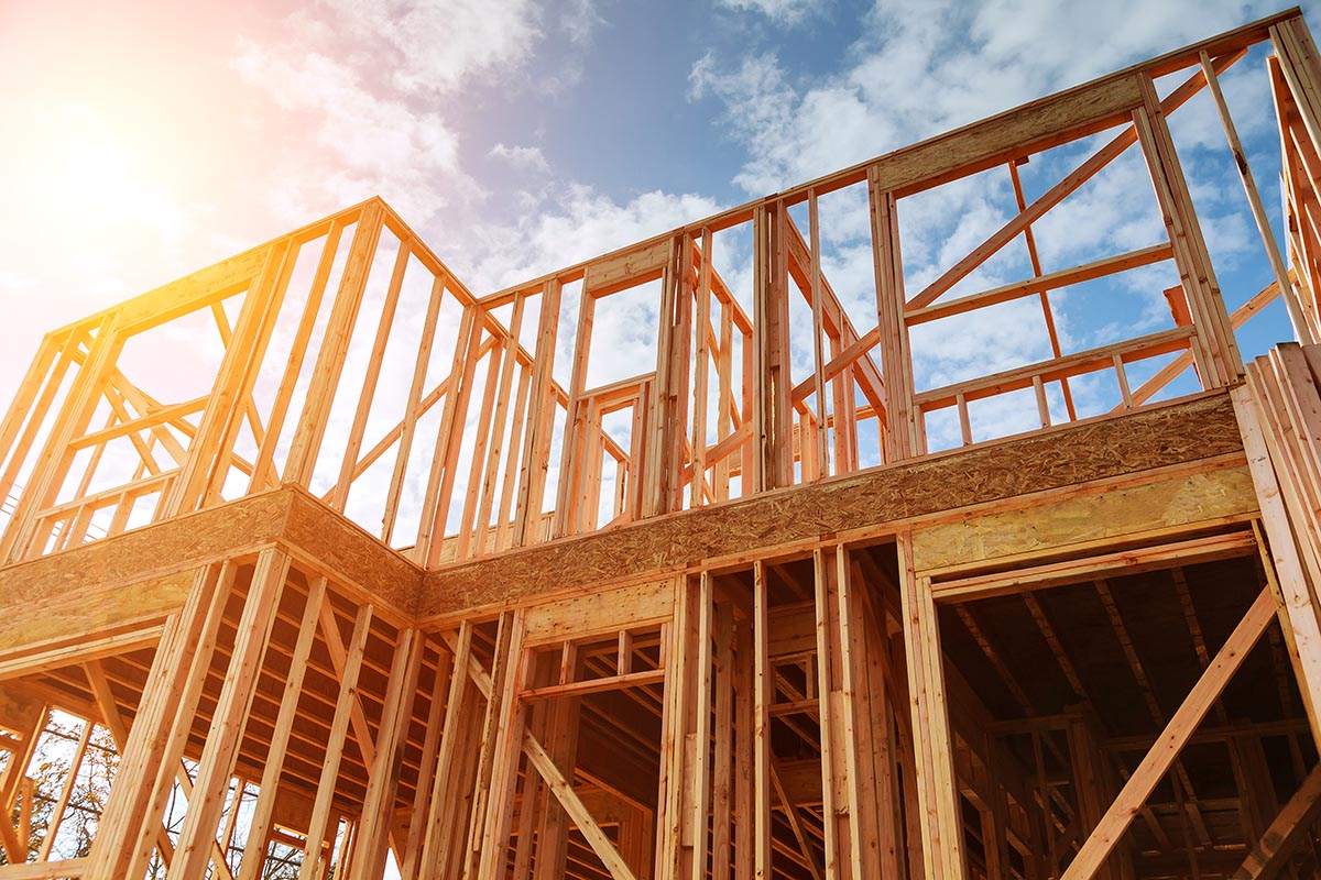 A wooden house frame under construction.