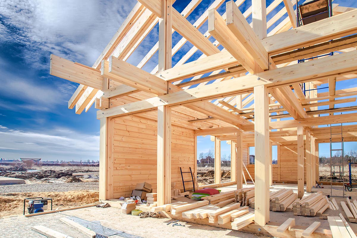 A wooden house frame under construction.